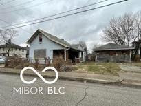 Distressed bungalow fixer-upper with boarded windows at 2916 E North St, Indianapolis, IN 46201