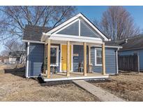 Charming bungalow with a yellow door and covered porch at 305 Hamilton St, Fortville, IN 46040