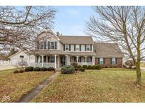 Charming two-story home featuring a welcoming front porch, manicured lawn, and mature landscaping at 442 S Meadow Song Ct, New Palestine, IN 46163