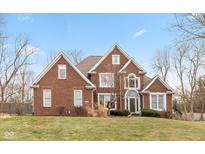 Brick two-story house with a spacious lawn and mature trees at 9711 Sunwood Way, Carmel, IN 46032