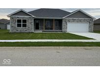 Charming single-story home featuring stone accents, a covered porch, and a well-maintained lawn at 20 Lancaster Ct, Trafalgar, IN 46181
