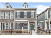 Charming gray two-story home with black shutters, a welcoming blue door, and a wrought iron fence at 537 Steinbeck Pl, Carmel, IN 46032