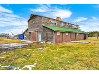 Rustic barn with green roof and brown siding, multiple stalls, and a spacious layout at 7615 Fayette Rd, Lebanon, IN 46052