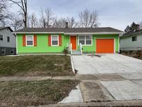 Green house with orange garage door and shutters at 8214 E 36Th St, Indianapolis, IN 46226