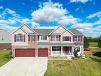 Two-story brick home with red accents and a two-car garage at 10723 Pokagon Way, Indianapolis, IN 46239