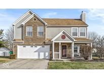 Charming two-story home featuring a brick facade, attached garage, and welcoming front porch at 15 Daniel Cir, Brownsburg, IN 46112