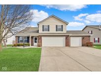 Charming two-story home featuring a brick facade, three-car garage, and well-maintained lawn at 2379 Liatris Dr, Plainfield, IN 46168