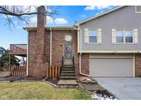 Brick and gray siding townhouse exterior with attached two-car garage and deck at 7564 Farm View E Cir, Indianapolis, IN 46256