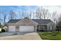 Charming brick home featuring a spacious three-car garage and well-maintained front lawn at 8341 Hunters Meadow Ct, Indianapolis, IN 46259