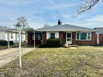 Brick ranch home with carport and landscaped lawn at 912 Alhambra Dr, Anderson, IN 46012