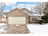 Charming brick home featuring an attached garage, well-maintained lawn, and snow-covered driveway at 9519 Summer Ridge Pl, Indianapolis, IN 46260