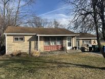 Ranch house with stone facade, brown roof, and a nicely landscaped lawn at 100 S Manhattan Ave, Muncie, IN 47303