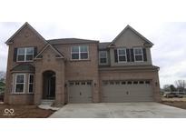 Stunning two-story brick home with a three-car garage and covered entryway, presenting an inviting curb appeal at 1144 Ridgevine Rd, Greenwood, IN 46143