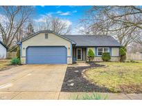 Charming single-story home featuring a blue garage door, complementing siding and a well-maintained front yard at 12301 Van Spronsen Ct, Indianapolis, IN 46236