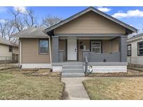 Beige house with gray brick details, front porch, and landscaped lawn at 1825 Mansfield St, Indianapolis, IN 46202