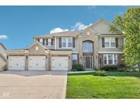 Stunning two-story home with a three-car garage, stone accents, and a well-manicured lawn at 18725 Wychwood Pl, Noblesville, IN 46062