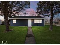 Newly built home with a dark blue exterior, well-manicured lawn, and walkway at 403 Wellington Blvd, Shelbyville, IN 46176