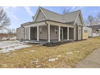 Charming gray home featuring a covered front porch with white pillars and gray trim at 429 Wood St, Greenfield, IN 46140