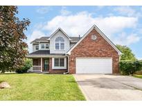 Charming two-story home featuring a brick facade, attached garage, and well-manicured lawn at 493 Clearwater Blvd, Whiteland, IN 46184