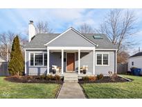 Charming gray house with a covered porch and well-manicured lawn at 5449 Indianola Ave, Indianapolis, IN 46220