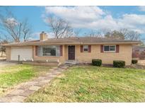 Ranch home with brick exterior, attached garage, and landscaped lawn at 6149 Winnpeny Ln, Indianapolis, IN 46220