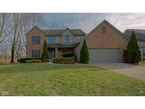 Charming two-story brick home with attached two-car garage and well-manicured front lawn at 10823 Knightsbridge Ln, Fishers, IN 46037