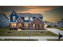 Charming two-story home with brick and blue siding and a well-manicured front lawn at 11970 Prominence Pl, Fishers, IN 46037