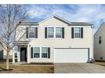 Two-story house with beige vinyl siding, a white garage door, and a well-maintained lawn at 1326 Central Park Dr, Shelbyville, IN 46176