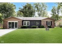 Charming single-story home with brick and wood facade, surrounded by a lush green lawn and mature trees at 137 Catherine Dr, Westfield, IN 46074