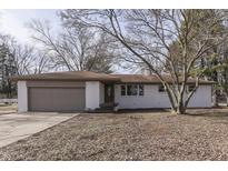 Newly painted brick ranch home with a brown roof, attached garage, and landscaping at 5324 Mann Rd, Indianapolis, IN 46221