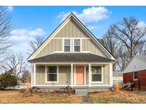 Charming craftsman style home with a gray exterior, pink door and front porch at 5704 E 16Th St, Indianapolis, IN 46218