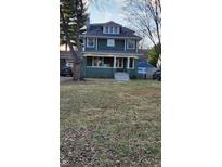 Green two-story house with a spacious lawn and attached garage at 5844 Central Ave, Indianapolis, IN 46220