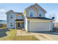 Charming two-story home features a two car garage, quaint landscaping, and a welcoming walkway to the front door at 6623 Pasco Ln, Plainfield, IN 46168