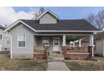 Gray house with brick porch and rocking chairs, well-maintained lawn at 710 Colescott St, Shelbyville, IN 46176