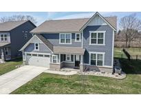 Charming two-story home features a two car garage and a nicely manicured lawn at 9812 Ridgecrest Ln, McCordsville, IN 46055