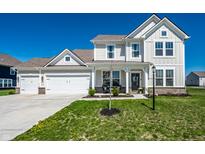Charming two-story home featuring a two-car garage, welcoming front porch, and well-maintained lawn at 11034 Saddlebred Dr, Indianapolis, IN 46239