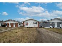 Three brick houses on a lot with grassy yards and a shared driveway at 1450 Golay St, Indianapolis, IN 46203