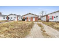 Brick duplex home with a gravel driveway and small front yard at 1454 Golay St, Indianapolis, IN 46203