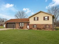 Brick ranch home with attached garage and landscaped lawn at 3774 Cameron Ct, Anderson, IN 46012