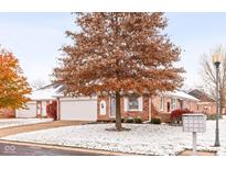 Brick ranch home with attached garage, covered entry, and snow-covered landscaping at 1437 Holiday W Ln, Brownsburg, IN 46112