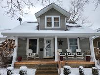 Charming home featuring a lovely front porch with chairs, perfect for relaxing and enjoying the neighborhood in winter at 1728 California St, Columbus, IN 47201