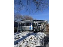Gray brick ranch home with white porch and blue door, freshly landscaped yard at 2414 Walker Ave, Indianapolis, IN 46203