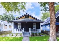 Charming home featuring a beautiful front yard and inviting front porch with white railing at 722 N Linwood Ave, Indianapolis, IN 46201