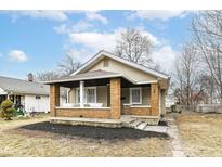 Charming bungalow-style home with a covered front porch and freshly mulched landscaping at 940 Cameron St, Indianapolis, IN 46203