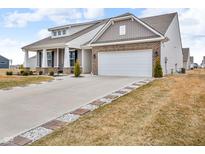 Charming home with a brick-accented facade, two-car garage, and meticulous landscaping at 9866 Olympic Blvd, Pendleton, IN 46064
