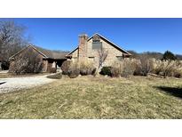 Large brick home featuring a chimney and a gable roof, surrounded by natural landscaping at 1072 S State Road 67, Martinsville, IN 46151