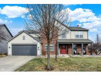 Charming two-story home with a brick facade, inviting front porch, attached garage and nicely landscaped yard at 11977 Cobblestone Dr, Fishers, IN 46037
