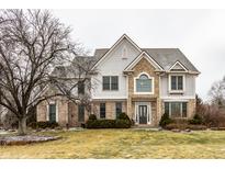 Beautiful two-story home boasts a brick and siding exterior and mature landscaping at 13803 Smokey Ridge Dr, Carmel, IN 46033