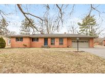 Charming brick ranch home with an attached two car garage and well manicured lawn at 2939 Stamm Ave, Indianapolis, IN 46240