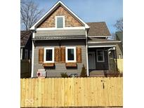 Charming two-story home featuring gray siding, decorative wood shutters, and a classic covered front porch at 350 E Minnesota St, Indianapolis, IN 46225